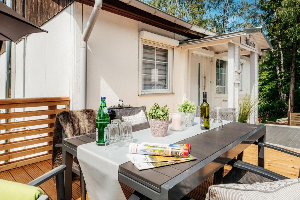a table on a deck with drinks on it at Hillside Braunlage in Braunlage