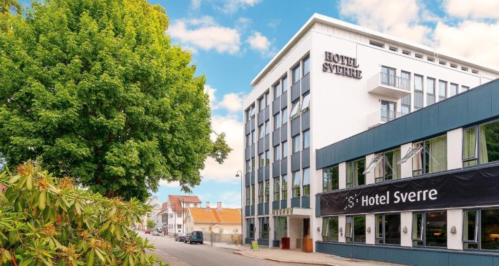 ein weißes Gebäude in einer Straße mit einem Baum in der Unterkunft Best Western Hotel Sverre in Sandnes