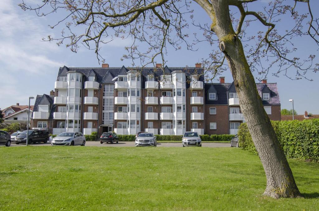 a large building with cars parked in a parking lot at FeWo Krüger 17 in Dahme