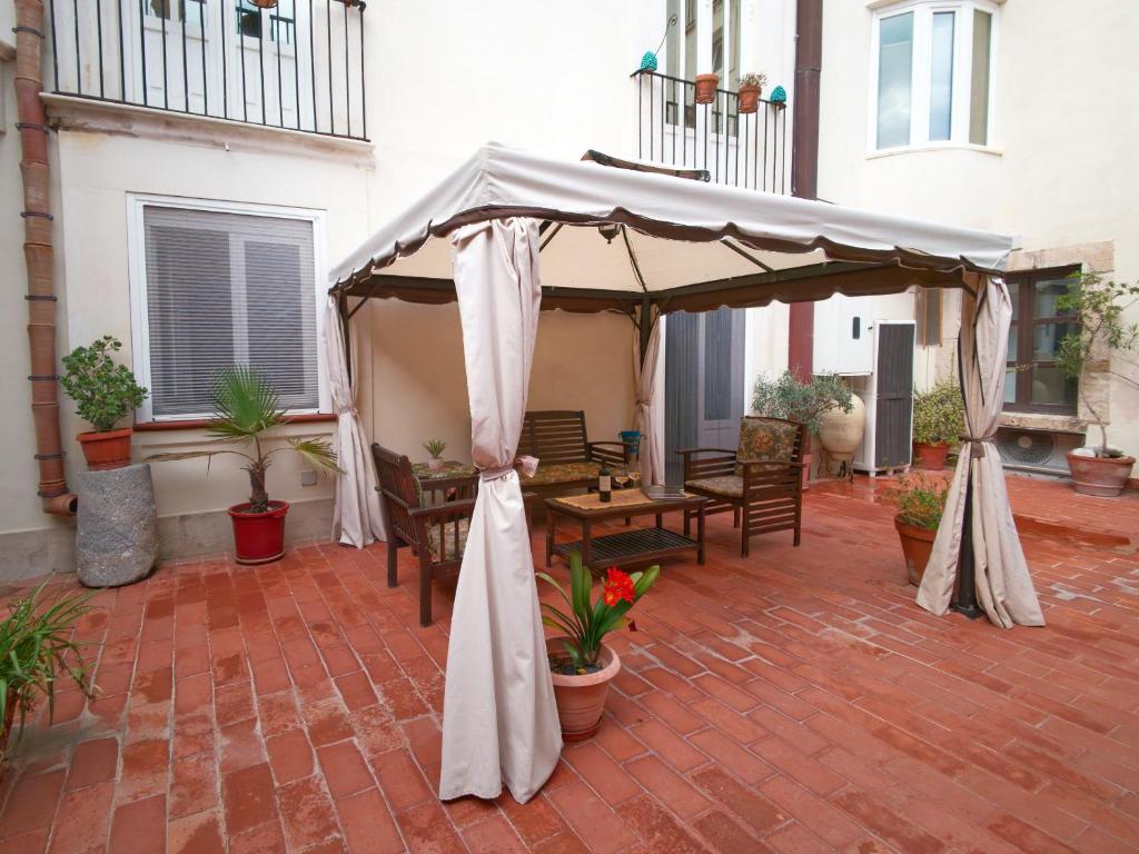a patio with a tent and tables and chairs at Dammuso Nuzzarè in Syracuse