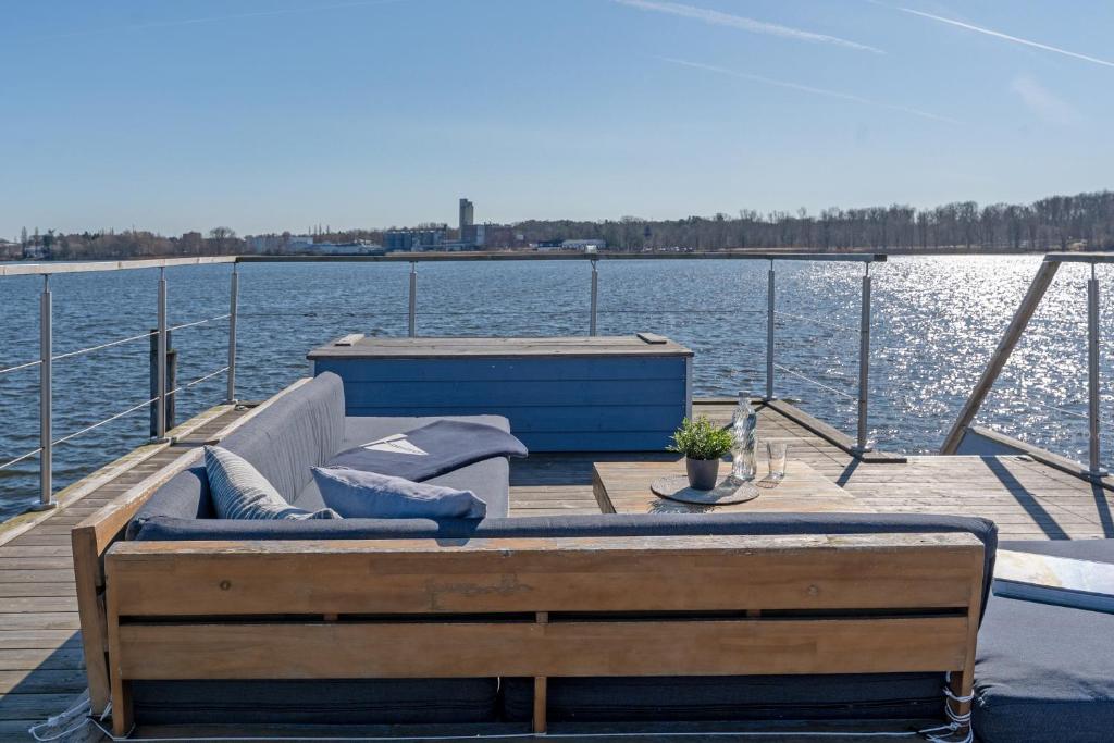 a wooden dock with a couch on the water at Snowbird in Lübeck