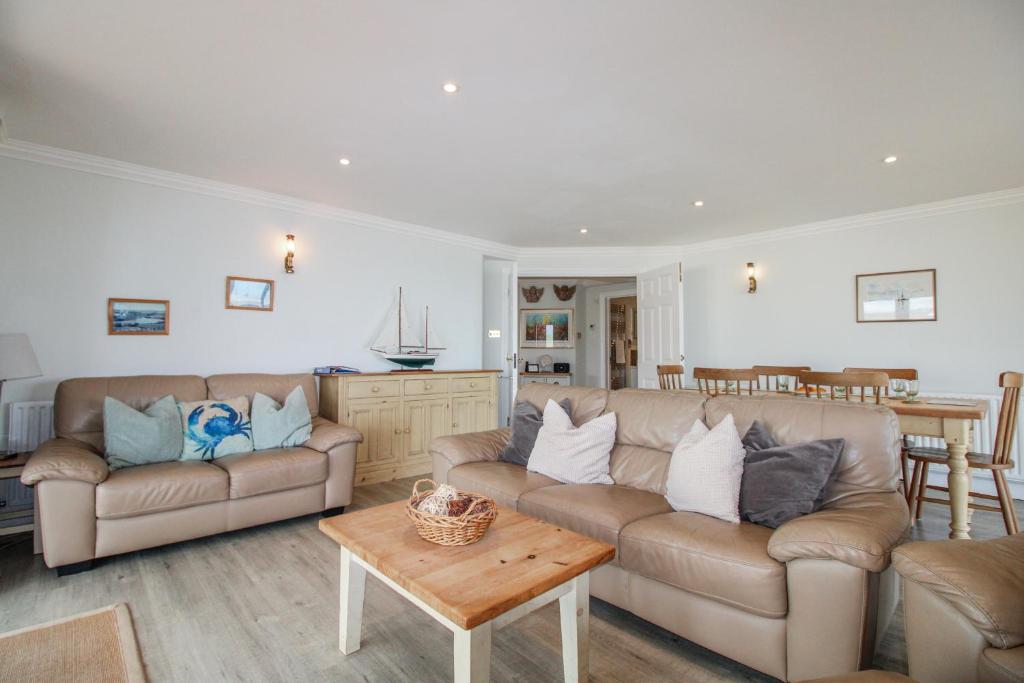 a living room with two couches and a table at 7 Thurlestone Rock in Kingsbridge