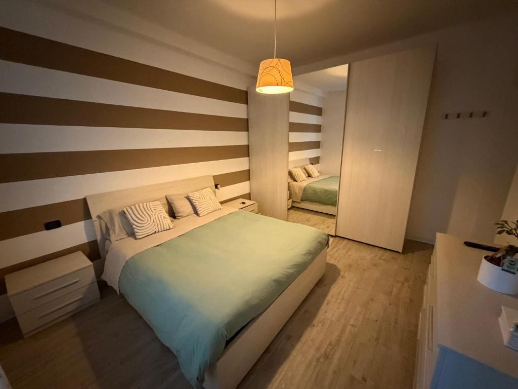 ein Schlafzimmer mit einem Bett und einer gestreiften Wand in der Unterkunft Gerenzone Bridge-Air conditioning in Lecco
