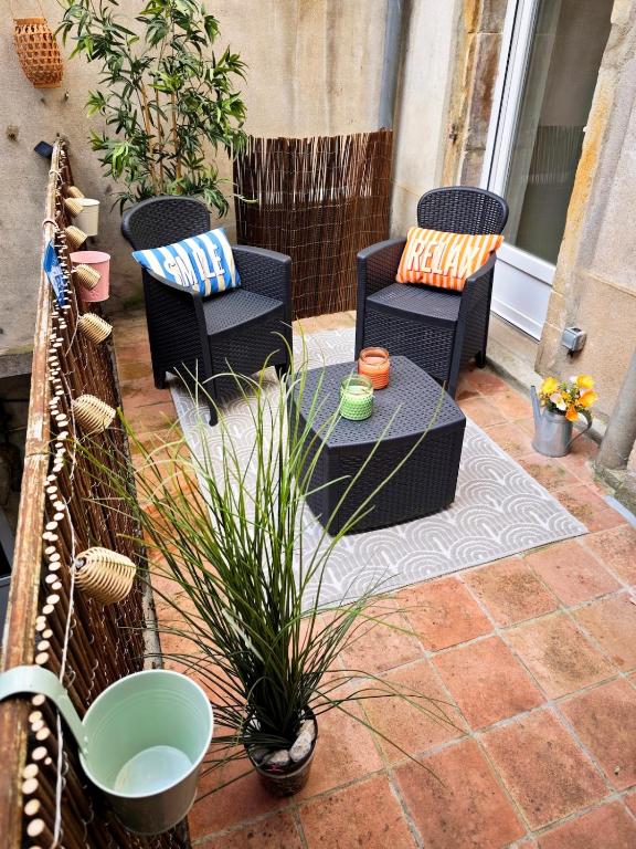 a patio with two chairs and a glass table at Le Cocon Des Arcades - Central, charmant balcon - in Limoux
