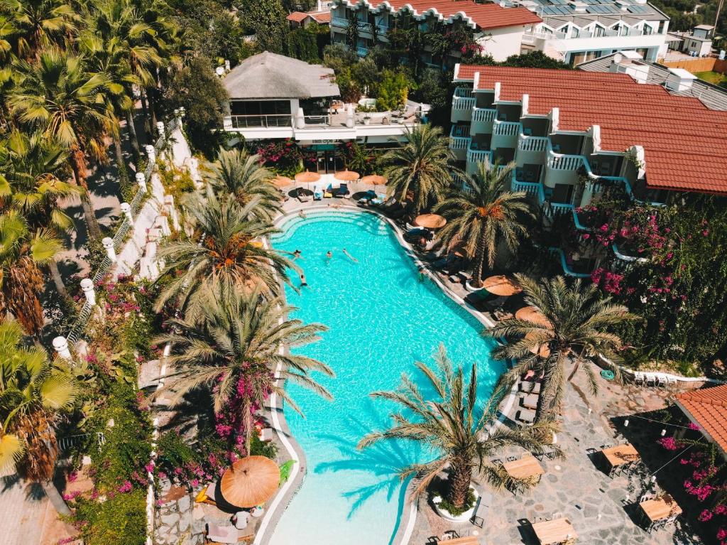 an aerial view of a resort swimming pool with palm trees at Deluxe Rooms Pet Friendly in Fethiye