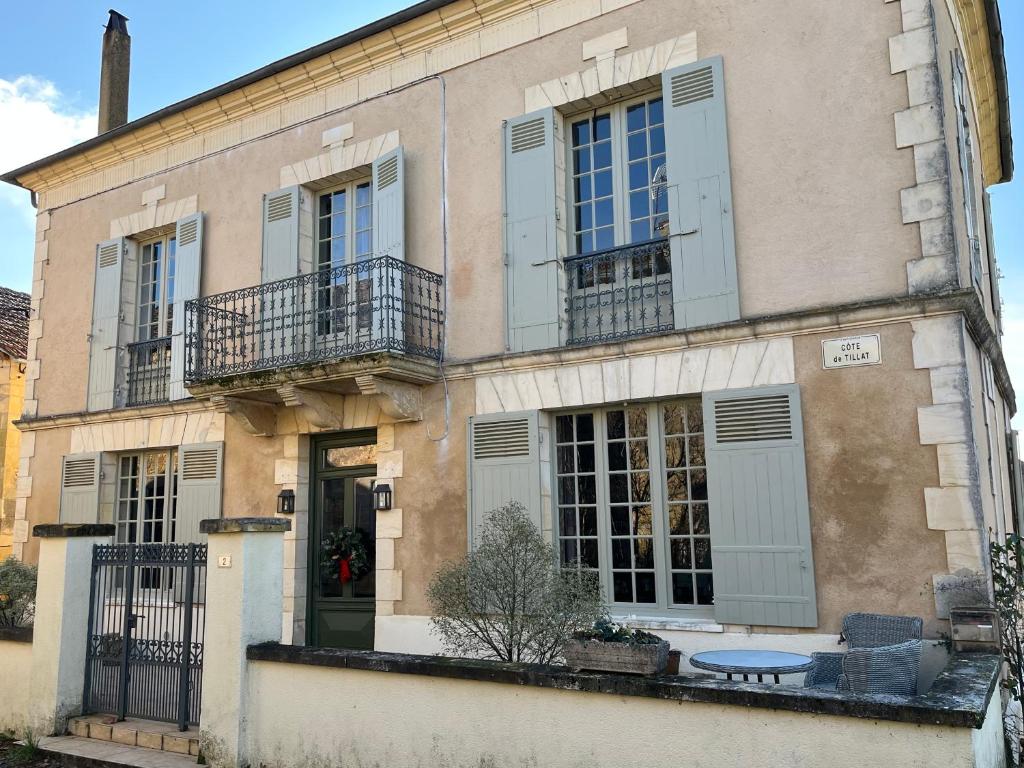a building with blue shutters and a table in front of it at Chez Lapage in Saint-Avit-Sénieur