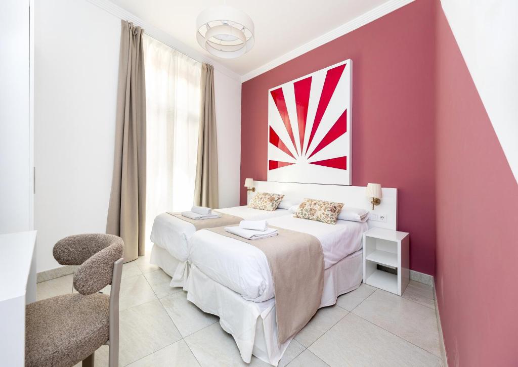 a pink bedroom with a bed and a red wall at Nest Style Granada in Granada