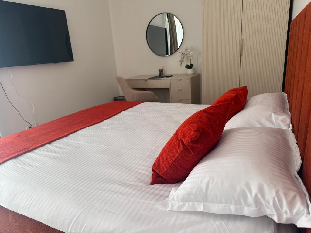 a bed with two red pillows on top of it at IDDA Concept 4 in Târgu-Mureş