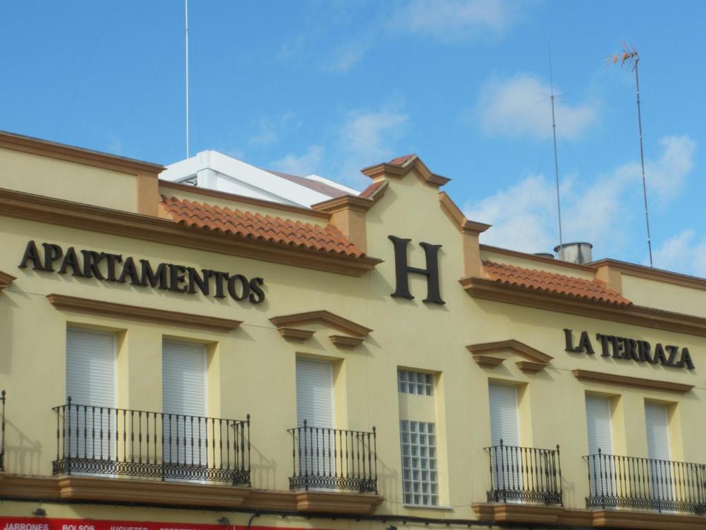 a building with a sign on the side of it at Apartamentos Turísticos La Terraza* in Las Cabezas de San Juan