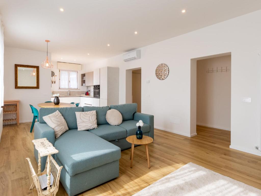 a living room with a blue couch and a kitchen at Apartment Lago di Luce by Interhome in Riva del Garda