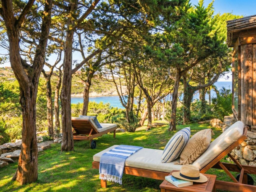 a bed in the grass with a view of the water at Apartment Mare 8 by Interhome in Porto Cervo