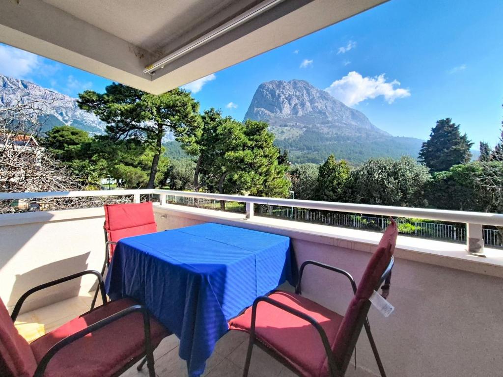 a table and chairs on a balcony with a view of mountains at Studio Rilić-1 by Interhome in Zaostrog