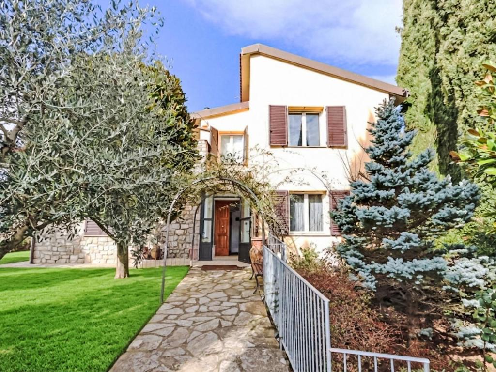 a white house with a fence and a yard at Apartment Villa Elisa by Interhome in Castellina in Chianti