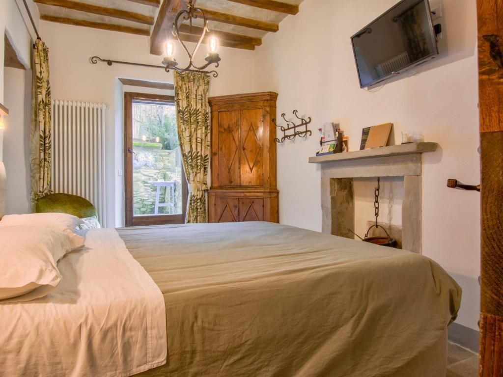 a bedroom with a large bed and a fireplace at Apartment Cia by Interhome in Palazzuolo sul Senio