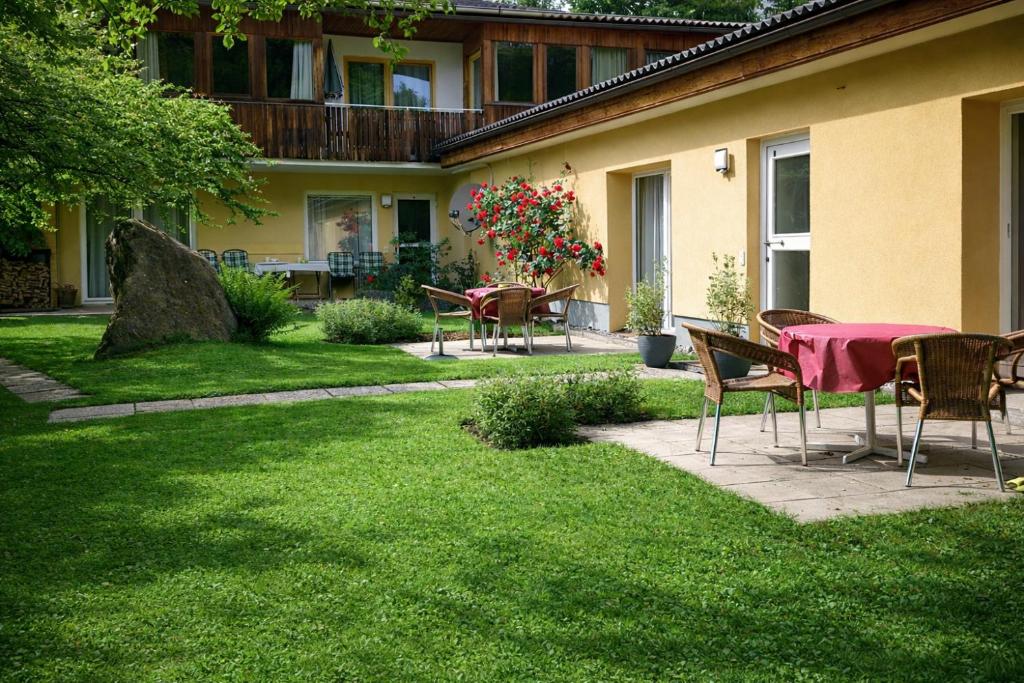 a patio with a table and chairs in a yard at Ferienwohnungen Vidoni in Bodensdorf