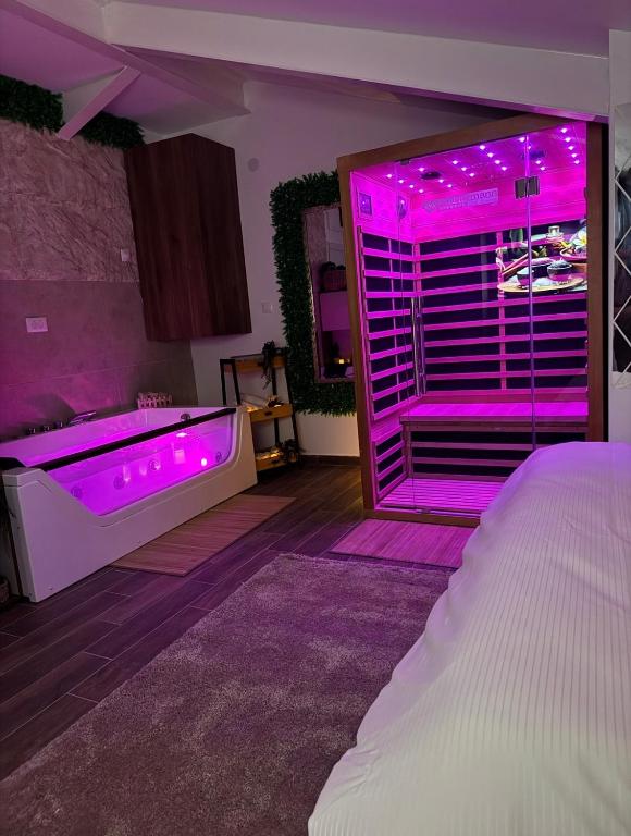 a bedroom with a tub with purple lights on it at SpaNish SKY 1 sauna&jacuzzi in Niš