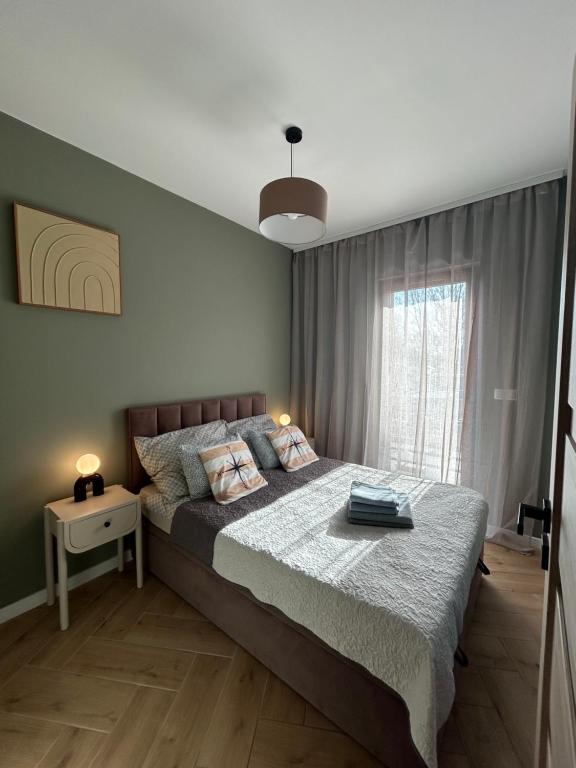 a bedroom with a large bed and a window at Twoja Przystań SŁAWA- Apartament przy plaży in Sława