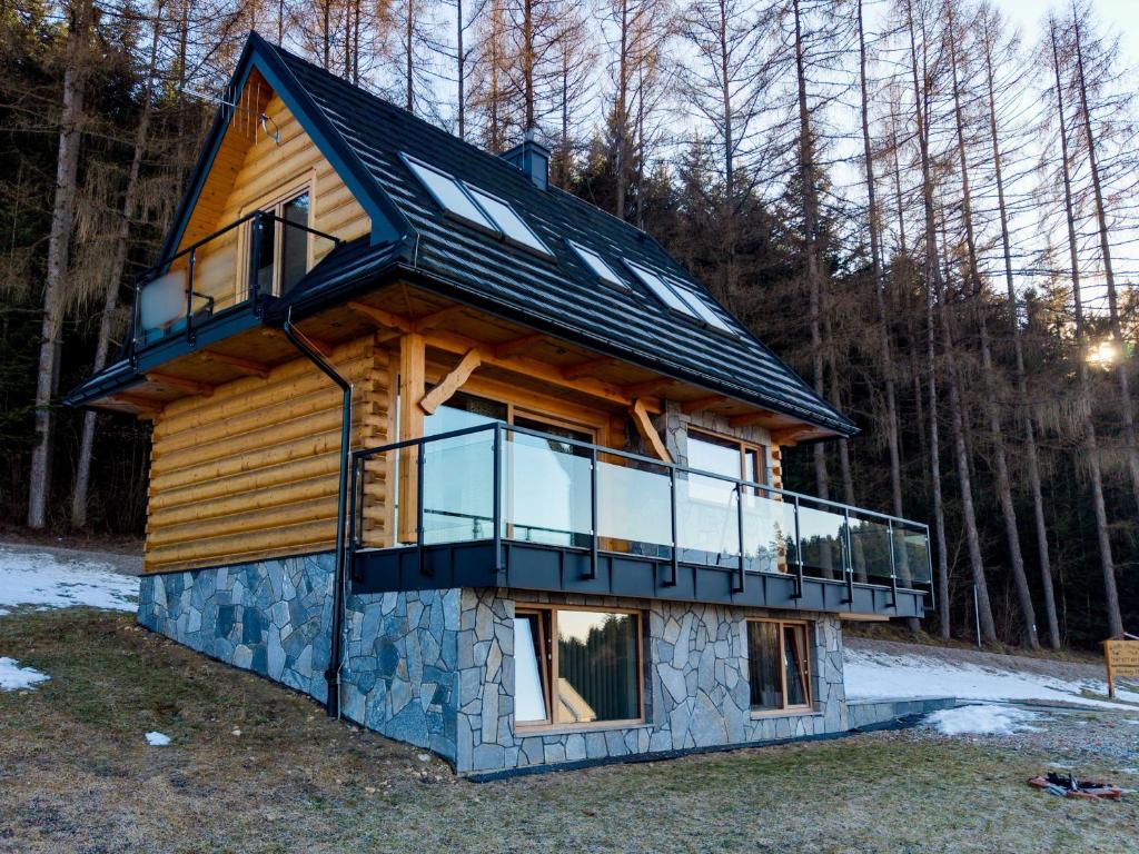 a log cabin with a balcony on the side at Ostoja Urnica in Falsztyn