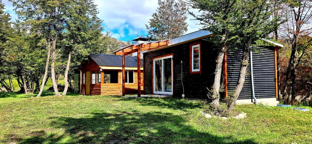 a small log cabin in the middle of a field at Cabaña Los Carpinteros in Cochrane