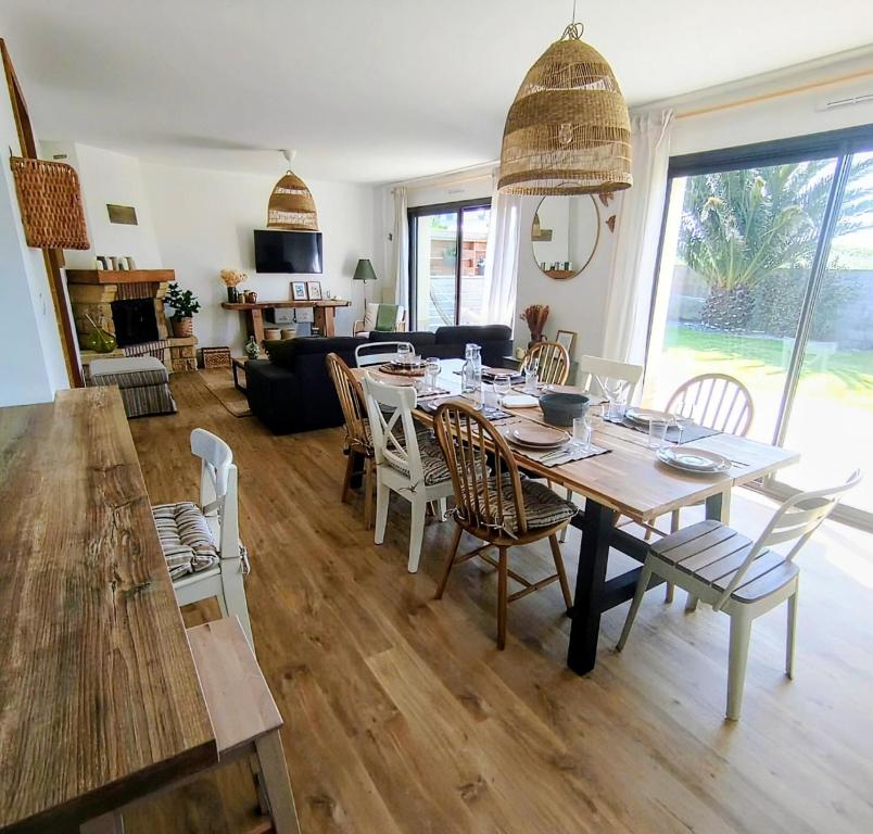 a dining room and living room with a table and chairs at Le cocon de Jules et Chloé in Cléder