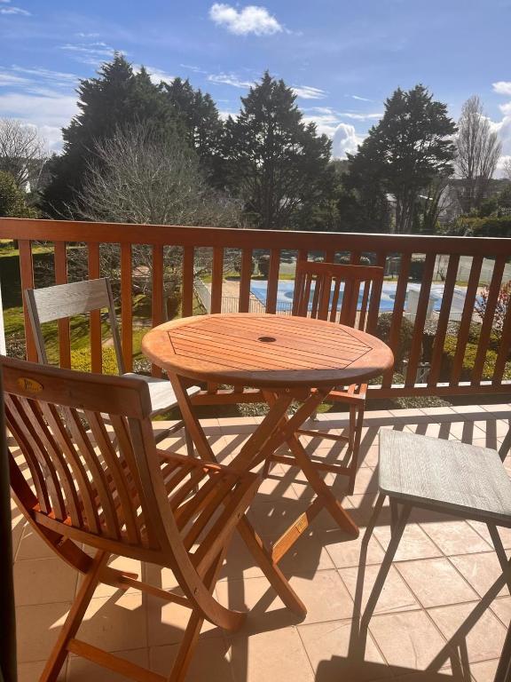 a wooden table and two chairs on a patio at Pool and beach studio in Quiberon