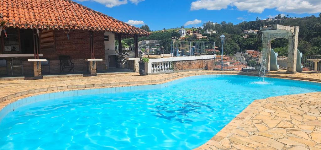 a large swimming pool with a water fountain at Pousada Hotel Casarão SerraNegra in Serra Negra