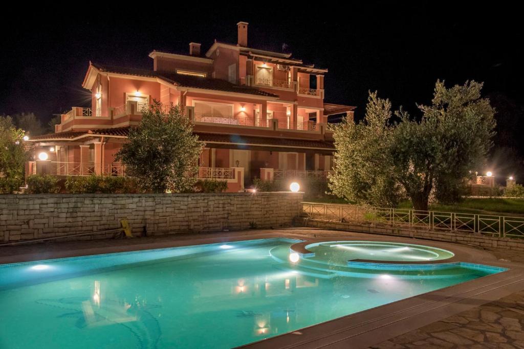 a swimming pool in front of a house at night at Epavlis Nadine Corfu in Corfu