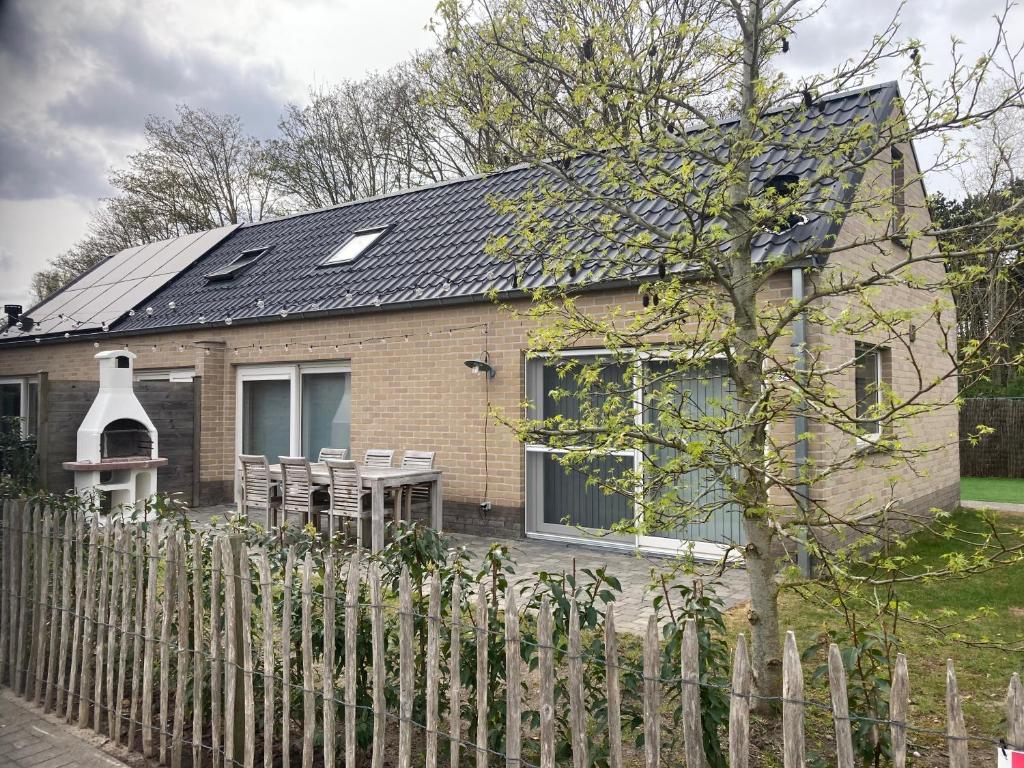 a brick house with a fence in front of it at Boszicht 32 in De Haan