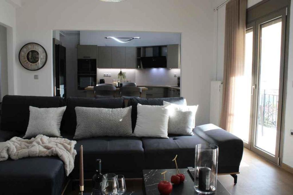 a living room with a black couch and a table at Theasis apt in Neméa