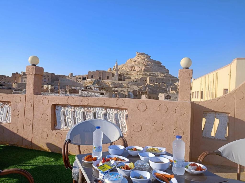 a table with bowls of food on top of a building at Al-BARNY HOTEL in Siwa
