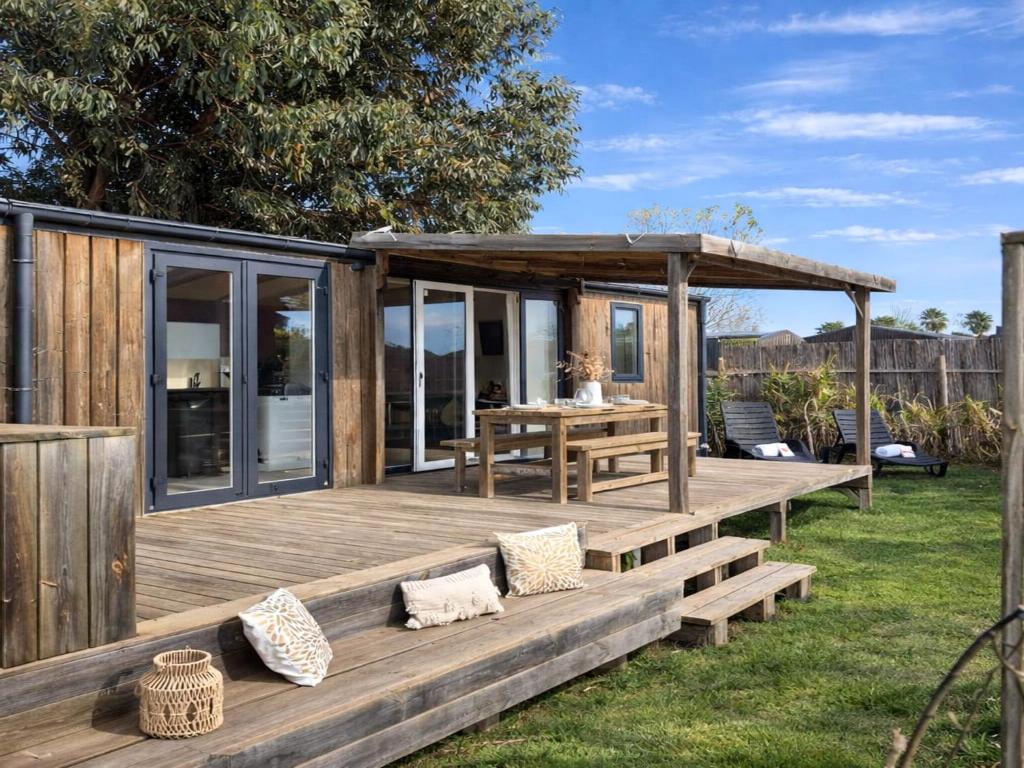 a wooden deck with a picnic table and a gazebo at Le Tropical Mobil Home 6 Personnes - Plage à 200m - Parc Aquatique - Camping 5 Etoiles Les Dunes in Torreilles