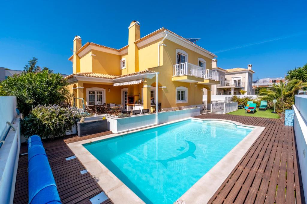 a villa with a swimming pool in front of a house at Villa dos Teixos in Cascais