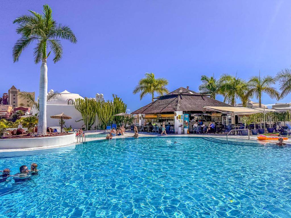 a pool at a resort with people in it at Adeje Paradise dreams in Playa Paraiso
