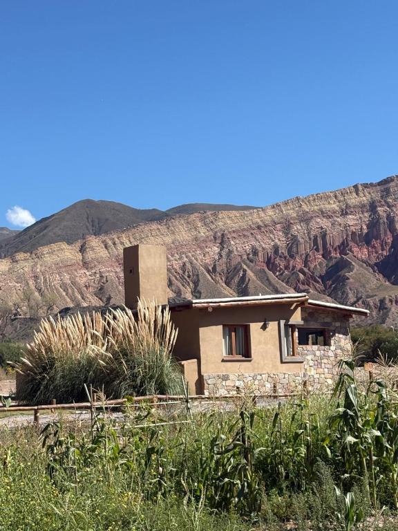 a house in the desert with mountains in the background at Cabañas La Nochera in Tilcara