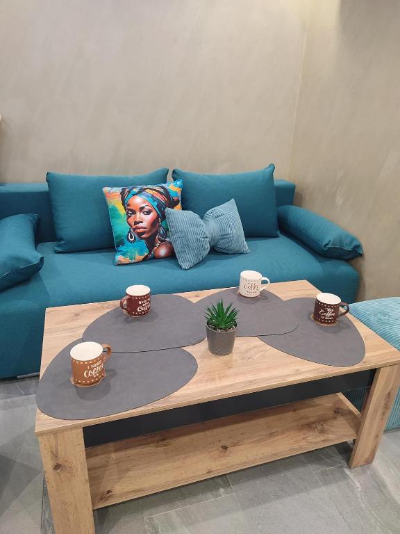 a blue couch with a coffee table with cups on it at Twins Apartments in Sozopol