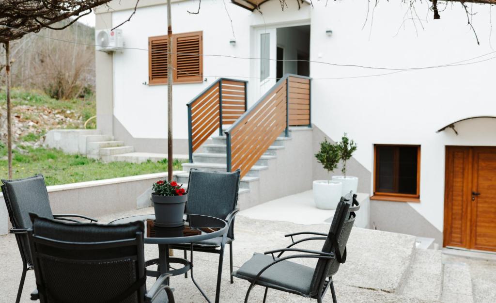 a patio with a table and chairs in front of a building at Guest house Ivan in Međugorje