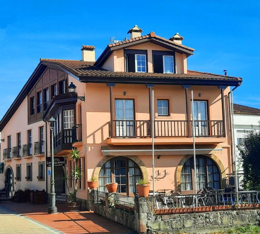 a large orange building with a balcony on a street at Hotel Rural en Escalante Las Solanas in Escalante