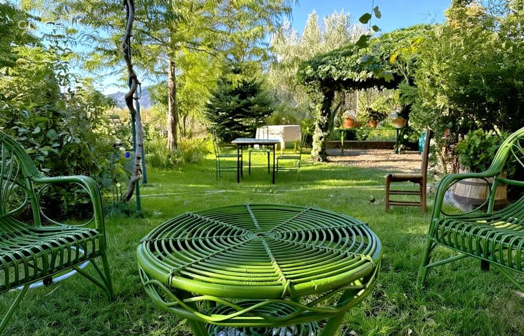 a group of green chairs and a table in the grass at I Santicelli in Morano Calabro