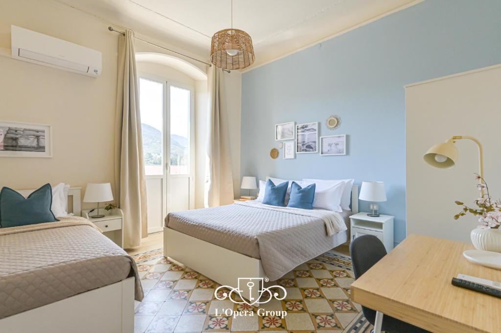 a bedroom with two beds and a table and a desk at Vestamonti Apartment in La Spezia