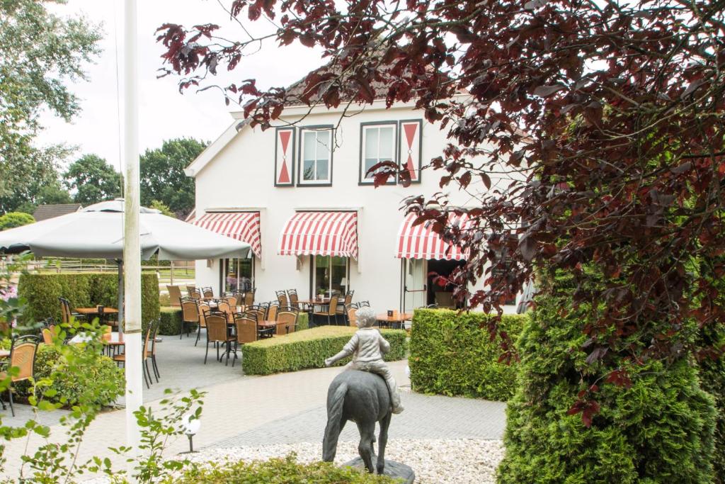 a statue of a woman riding a horse in front of a building at Hotel Restaurant Eeserhof in Ees