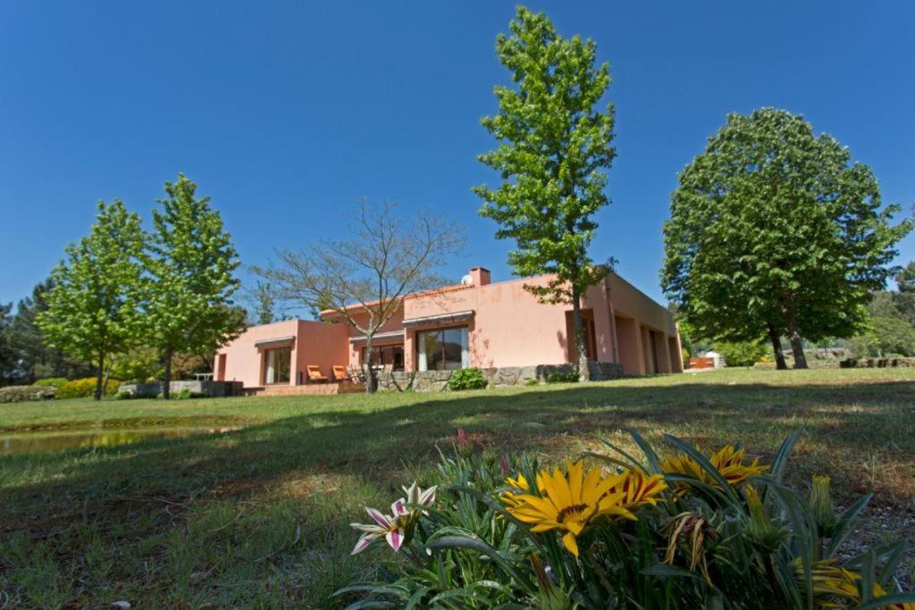a house with a yard with flowers in the grass at GuestReady - Tranquillity in Baião in Baião