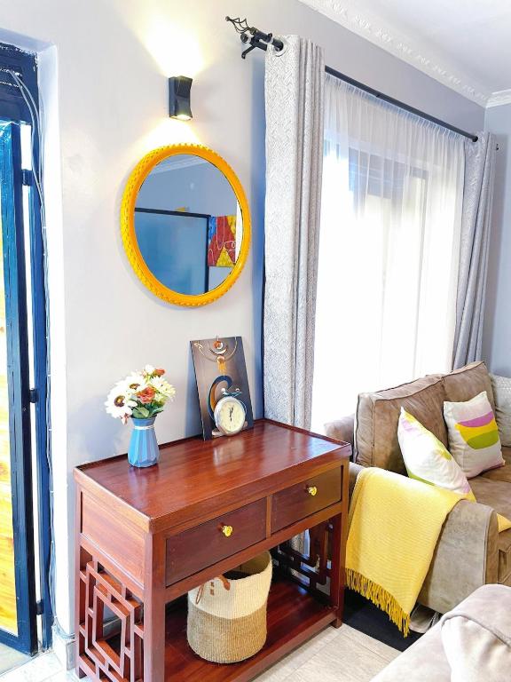 a living room with a table and a mirror at Lilac cottage in Gatunga