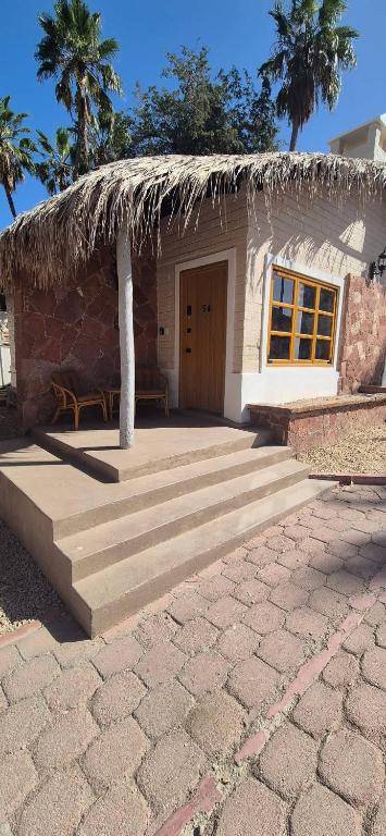 a small house with a straw roof and a stairs at Sandy Shores Cabaña 5 in La Paz