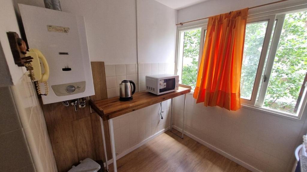 a kitchen with a counter with a microwave and a window at Calidez & Luz Rosario in Rosario
