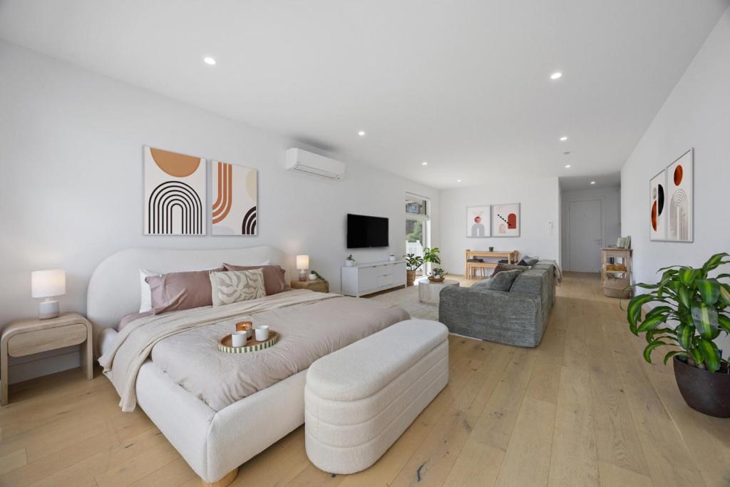 a white bedroom with a large bed and a couch at Sunset Hideaway in Marino in Marino