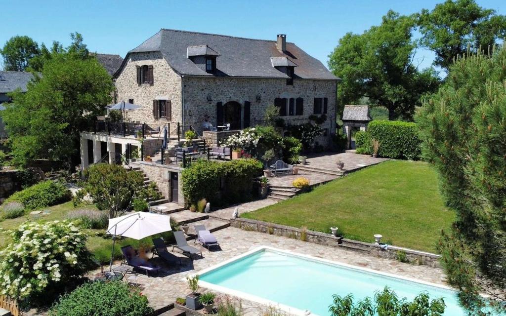 an estate with a swimming pool in front of a house at Soulages in Najac