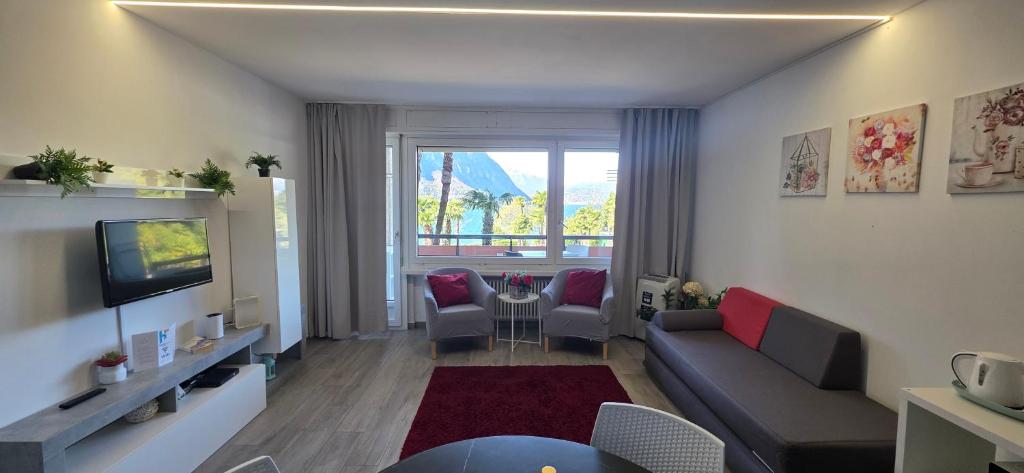 a living room with a couch and a tv at Adele's Apartment in Bissone