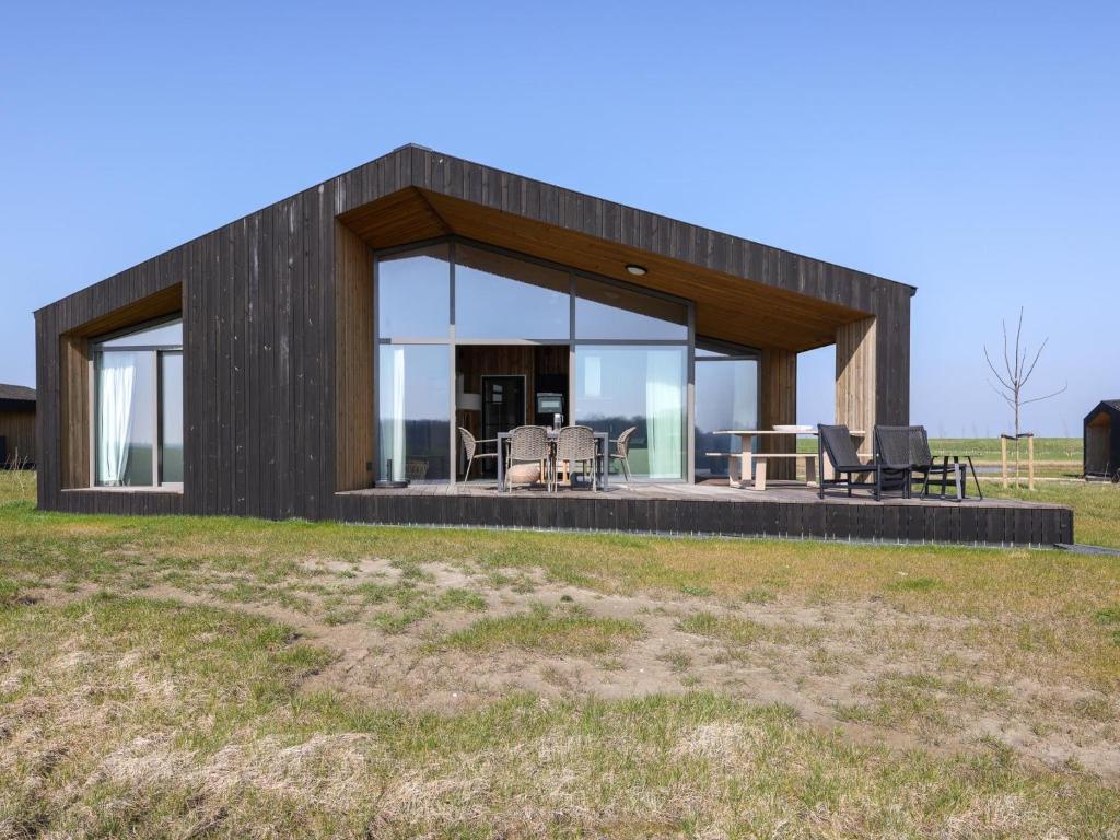a modern house with glass doors on a field at Natuurhuis Houtkant in Wissenkerke