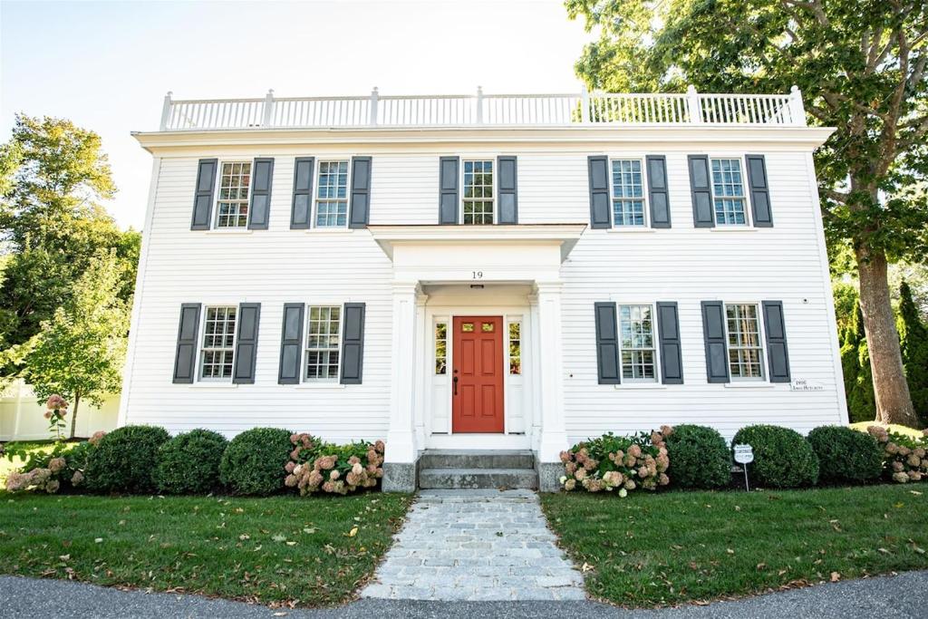 ein weißes Haus mit einer roten Tür in der Unterkunft Dock Square House in Kennebunkport