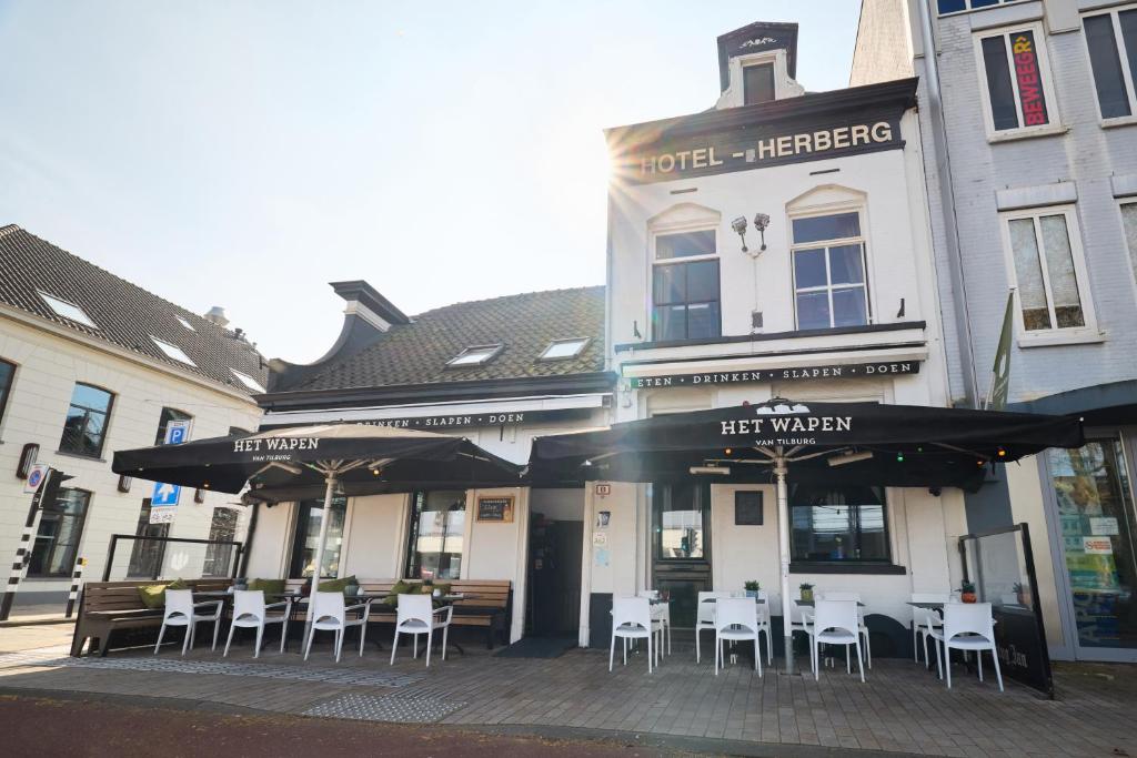 a restaurant with tables and chairs in front of a building at Herberg, Het Wapen van Tilburg in Tilburg